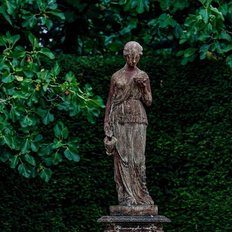 Dans les jardins, Hébé, déesse de la jeunesse, porte une amphore pour servir le vin à la table des dieux de l’Olympe.